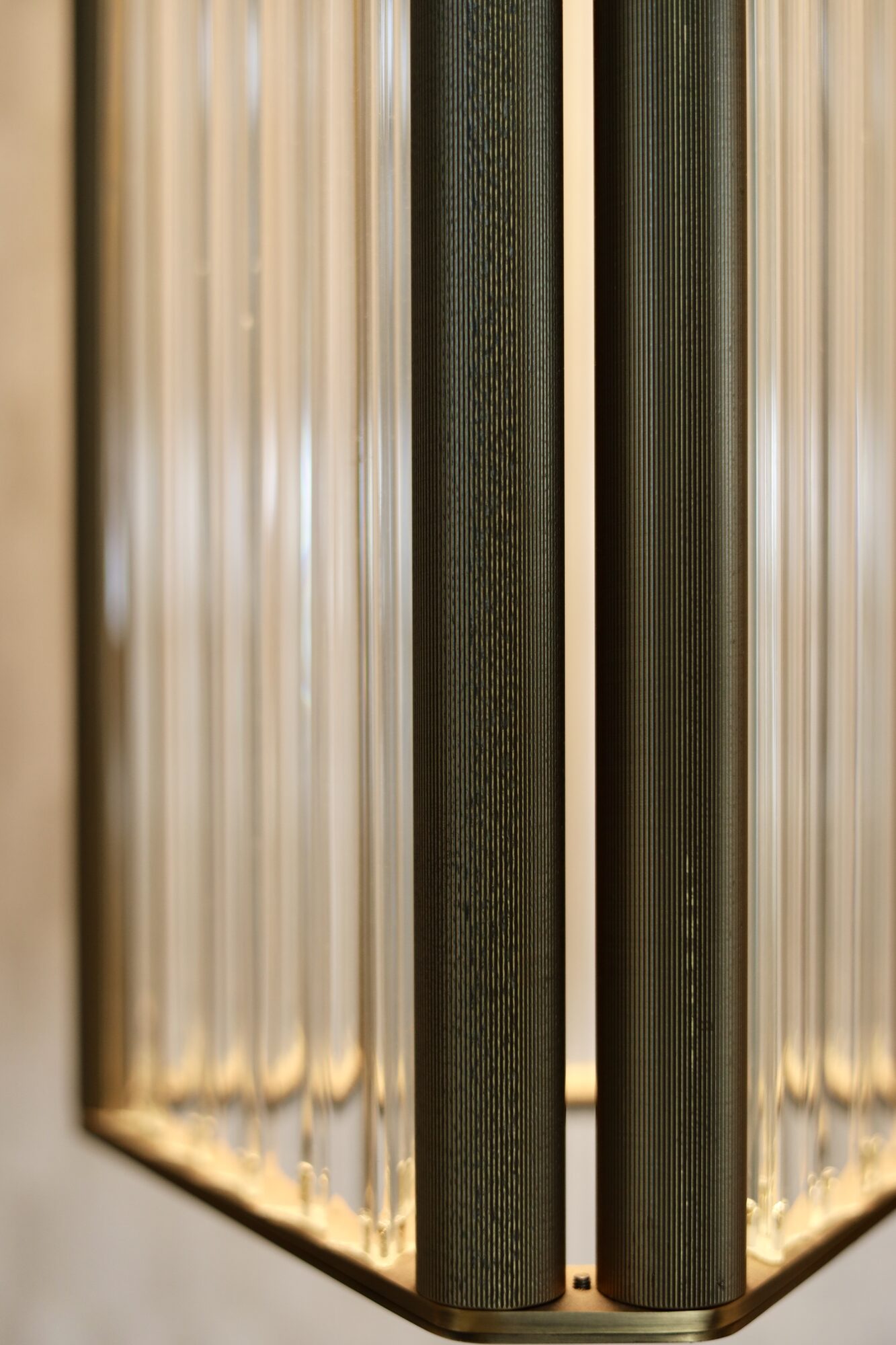 Macro detail of a precision-engineered brass and glass rod light fixture showing technical fabrication quality